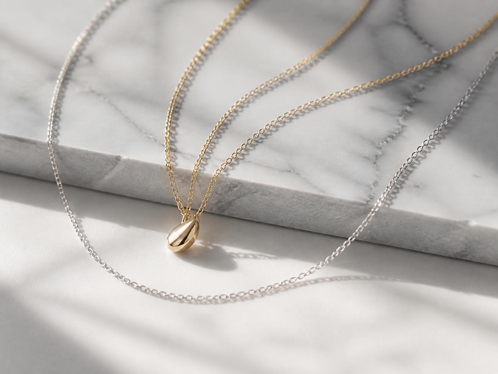 Feine Kette in Gold und Silber auf Marmor